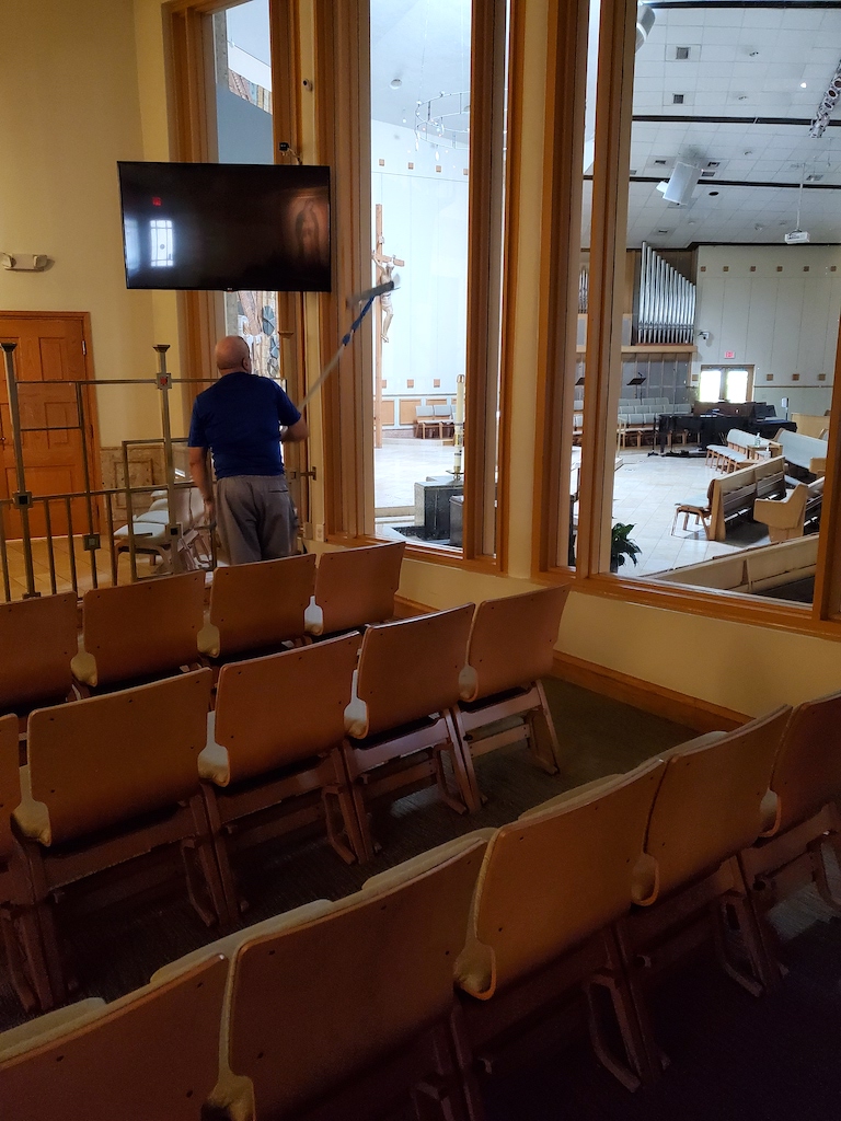 janitor cleaning church windows